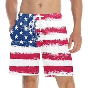 May include: White swim trunks with a distressed American flag print in red, white, and blue.