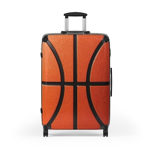 May include: A rolling suitcase with a basketball design. The orange suitcase has a textured surface and black lines that mimic the panels of a basketball. It has a retractable handle and black trim.