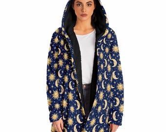 May include: A dark blue hooded cloak featuring a repeating pattern of golden suns, crescent moons, and small stars. The garment has a black interior lining and an open front design, providing a long-sleeved, loose-fitting silhouette.