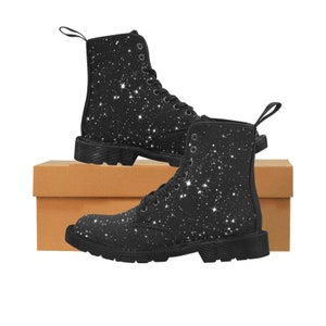 Puede incluir: Botas negras de lona con estampado de galaxia de purpurina blanca. Las botas tienen cierre de cordones y suela gruesa.