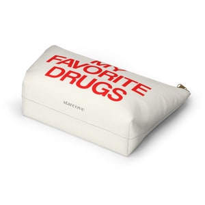 May include: White canvas zippered pouch with the text "MY FAVORITE DRUGS" in red lettering. The pouch is made by starcove.
