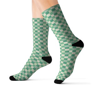 Könnte beinhalten: Ein Paar grün-weiß karierte Socken mit schwarzen Fersen und Zehen.