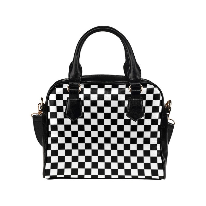 May include: A black and white checkered handbag with a top handle and a shoulder strap.