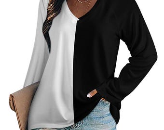 May include: A long-sleeve shirt featuring a color-blocked design with a white right side and a black left side. The garment has a V-neckline and is paired with light blue denim shorts and a tan clutch bag held at the side.