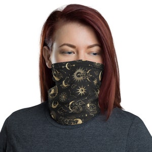 May include: A black face mask with a gold celestial pattern featuring moons, stars, and clouds.