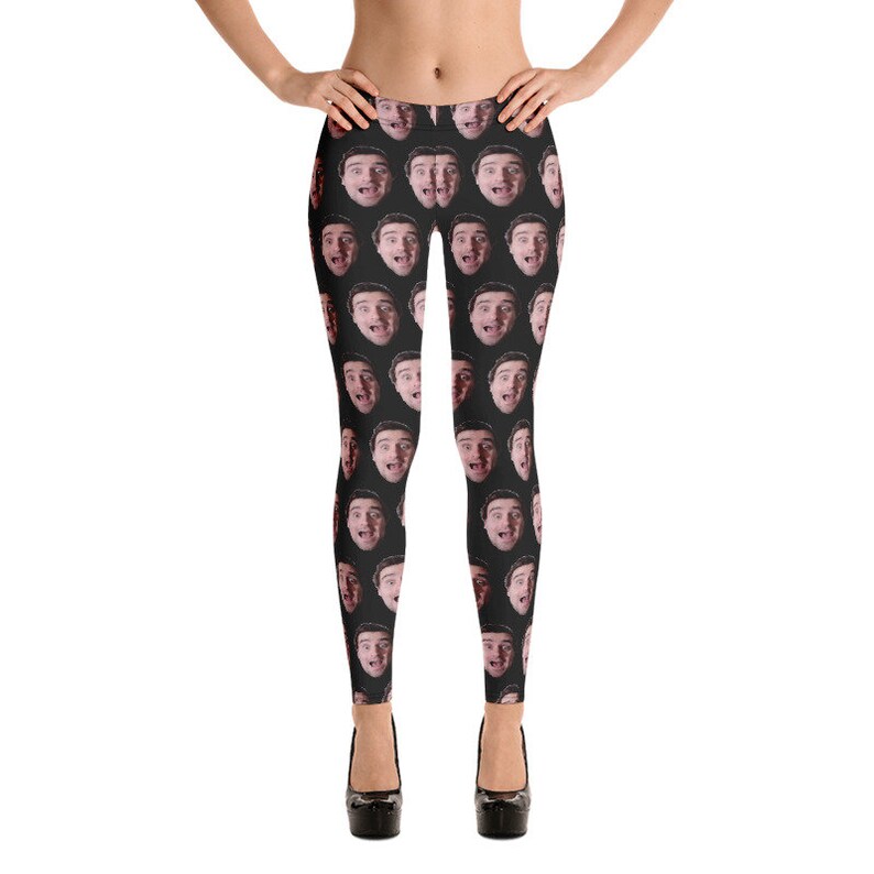 May include: Black leggings featuring a repeating pattern of a person's face. The faces are in various expressions, with open mouths and surprised looks. The leggings are worn with black platform heels.