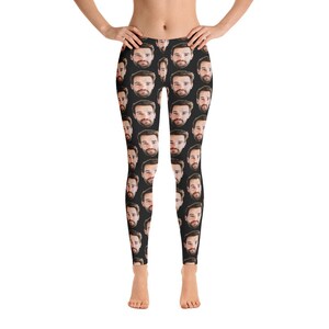 May include: Black leggings featuring a repeating pattern of a man's face. The faces are in a realistic style with dark hair and beards. The leggings are form-fitting and reach the ankles.