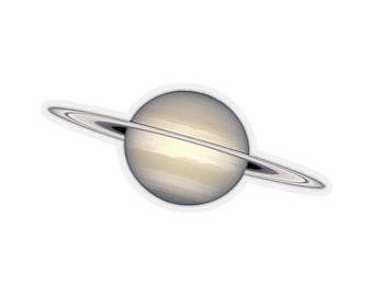 May include: A close-up of a sticker featuring a detailed illustration of Saturn, a gas giant planet with prominent rings. The planet is depicted in a pale yellow and white color scheme, with a subtle texture representing its swirling clouds. The rings are thin and silver, encircling the planet.