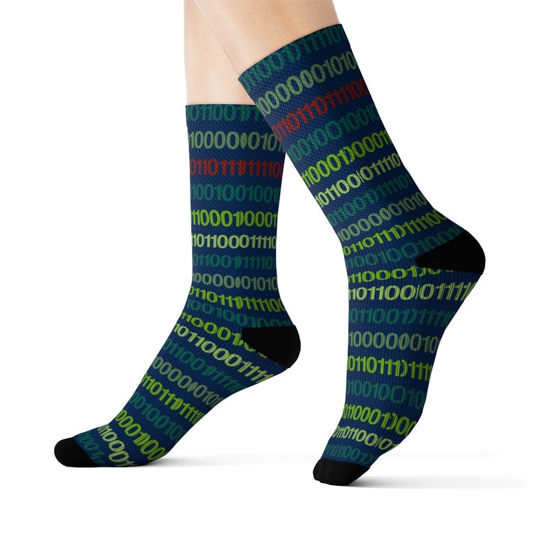 May include: A pair of blue socks featuring a pattern of colourful binary code. The socks are made from a soft, comfortable material and are ideal for everyday wear.