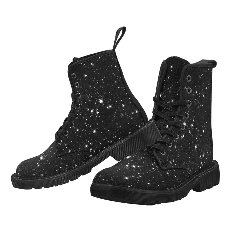 Puede incluir: Botas negras de lona con un patr&oacute;n de estrellas blancas de purpurina. Las botas tienen cordones y una suela gruesa.