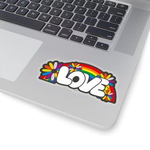 May include: A sticker with a rainbow arch and the word "LOVE" in white, surrounded by colorful flowers.