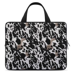May include: Black and white laptop bag with a spotted animal print design. The bag has a black handle and a zipper closure.