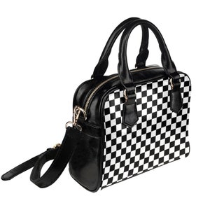 May include: Black and white checkered handbag with a black leather strap and top handles.