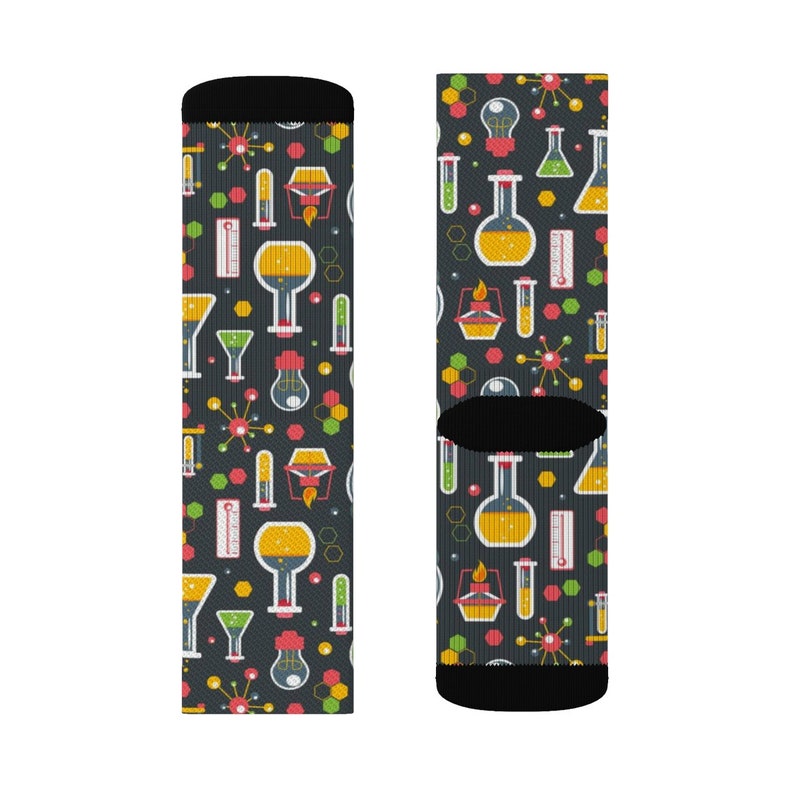 May include: A pair of black socks with a colorful pattern of beakers, test tubes, and other science-related imagery. The socks are designed for adults.
