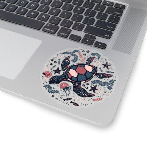 May include: A sticker featuring a stylized illustration of a sea turtle swimming in a circle of ocean life. The turtle is blue, pink, and black with a white background. The ocean life includes starfish, seashells, seaweed, and fish.