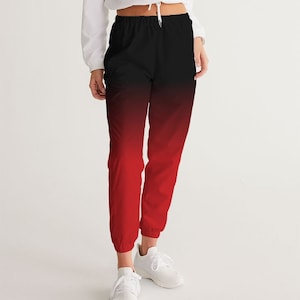 May include: Black and red ombre sweatpants with a drawstring waist and cuffed legs. The sweatpants are made of a soft, comfortable fabric.