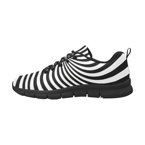 May include: Black and white striped running shoes with a swirling pattern. The shoes have a black sole and a white upper.