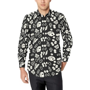 Pode incluir: Uma camisa preta de manga comprida com botões com uma estampa branca de cartas de jogar e fichas de pôquer.