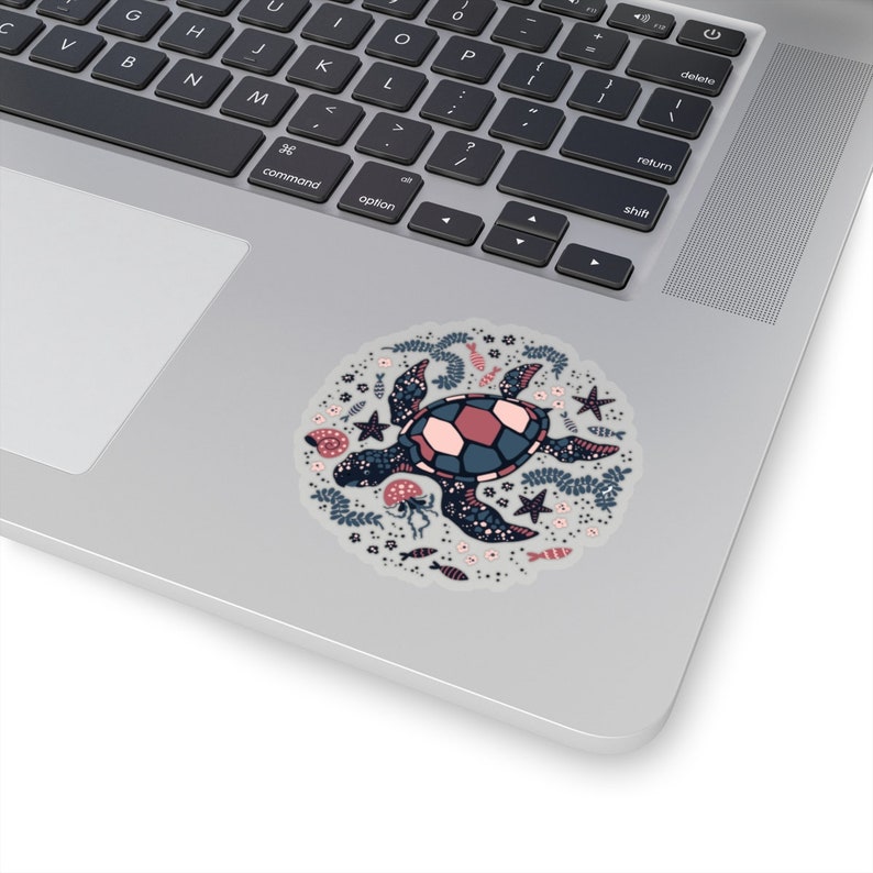 May include: A sticker featuring a stylized illustration of a sea turtle surrounded by various sea life, including starfish, seashells, and seaweed. The turtle is blue and pink with a white shell.