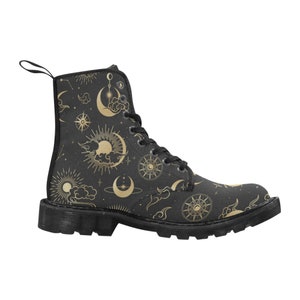 Puede incluir: Bota de combate negra con un dise&ntilde;o celestial dorado que incluye soles, lunas, estrellas y nubes. La bota tiene suela negra, cordones y una presilla. Una bota de moda para varios conjuntos.