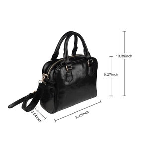May include: A black leather satchel handbag with a gold zipper and hardware. The bag has a top handle and a detachable shoulder strap. The bag measures 9.45 inches wide, 8.27 inches tall, and 3.54 inches deep.