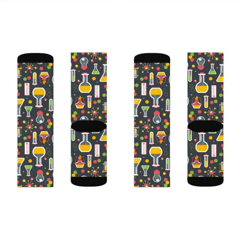 May include: Four pairs of black socks with a colorful science themed pattern. The pattern includes beakers, test tubes, and other lab equipment.