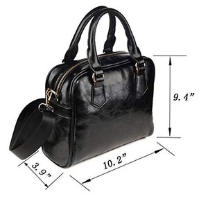 Op de afbeelding: Zwarte leren schoudertas met een bovenhandvat en een schouderband. De tas is 10,2 inch breed, 9,4 inch hoog en 3,9 inch diep.