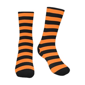 Könnte beinhalten: Ein Paar schwarze und orange gestreifte Socken. Die Socken sind aus einem weichen, bequemen Material gefertigt und perfekt für den Alltag.