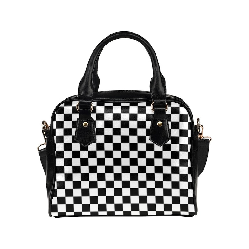May include: A black and white checkered handbag with a short shoulder strap. The bag has a top handle and a black leather trim.