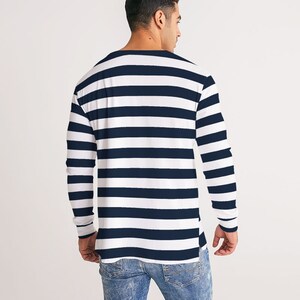 Op de afbeelding: Een shirt met lange mouwen met witte en donkerblauwe horizontale strepen. Het shirt heeft een ontspannen pasvorm en is iets langer aan de achterkant.
