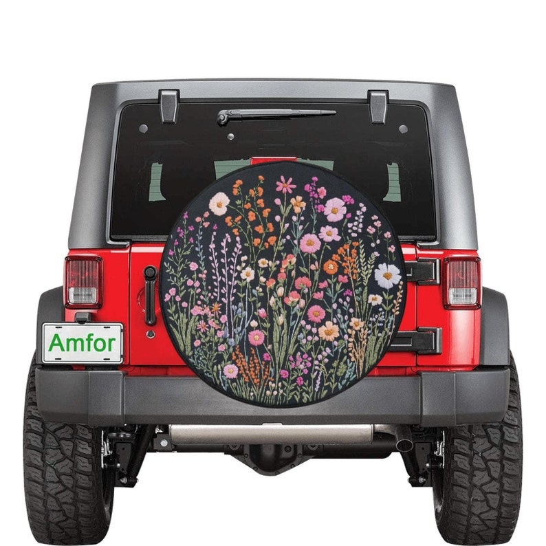 May include: A red Jeep Wrangler with a black spare tire cover featuring a floral design. The spare tire cover has a black background with colorful flowers and greenery.