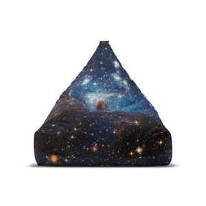 May include: A beanbag chair with a galaxy print. The fabric is dark blue with a scattering of white and yellow stars.