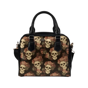 May include: Black handbag with a floral skull pattern. The skulls are surrounded by pink and orange roses.
