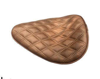 May include: A brown quilted motorcycle seat with a diamond pattern.