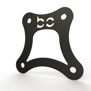 May include: A flat, black, four-sided metal bracket with curved edges and a large central cutout. The top section features a cutout of the letters "bc" and there is a circular hole located at each of the four corners of the frame for mounting purposes.