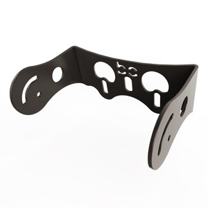 May include: Black metal wall mount with cutouts for holding three items. The mount has a curved shape and a logo that says "bc".