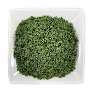 Könnte beinhalten: Eine weiße Keramik Schale gefüllt mit getrockneten grünen Petersilienblättern.