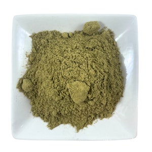 Puede incluir: Un pequeño plato cuadrado blanco lleno de un montón de polvo finamente molido de color verde claro.