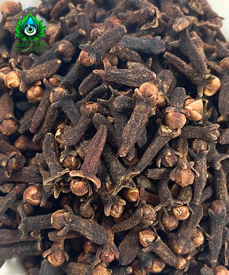 May include: A close-up image of a pile of dried cloves. The cloves are dark brown and have a slightly wrinkled texture.