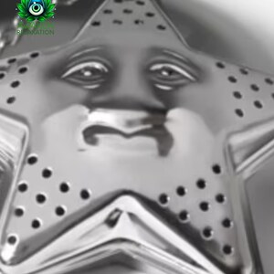 May include: A silver-toned metal tea infuser shaped like a five-pointed star. The surface features a molded face with eyes, a nose, and a mouth, along with small circular perforations across the star points for steeping loose leaf tea.