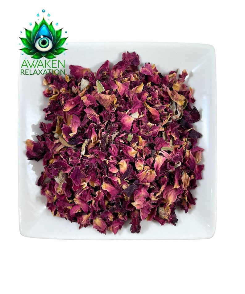 Op de afbeelding: Een vierkante witte kom gevuld met gedroogde rozenblaadjes in tinten diep magenta, donkerpaars en lichtgeel. Het logo van AWAKEN RELAXATION, met een groene lotusbloem en een oog, bevindt zich in de linkerbovenhoek van de afbeelding.