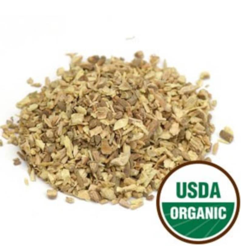 Puede incluir: Primer plano de un mont&oacute;n de ra&iacute;z de regaliz org&aacute;nica seca, de color marr&oacute;n claro y beige. La ra&iacute;z est&aacute; cortada en trozos peque&ntilde;os. La imagen tambi&eacute;n incluye un sello USDA Organic.
