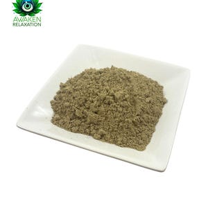 May include: A small white square dish filled with a light brown powder. The powder is a natural herbal supplement.