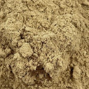 May include: A close-up view of a fine, dry, light brown powder with a granular and clumpy texture. The substance appears as a dense, uneven pile of small particles, showing variations in tone from tan to beige throughout the surface.