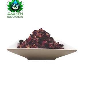 Op de afbeelding: Een witte, vierkante kom gevuld met een hoop gedroogde, diep magenta rozenblaadjes. Boven de kom staat een logo met een groene lotusbloem met een centraal oog en de tekst AWAKEN RELAXATION in groene hoofdletters.