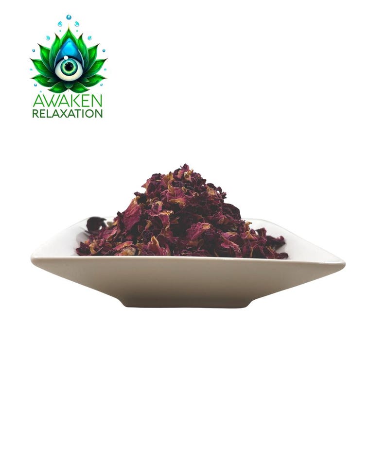Op de afbeelding: Een witte, vierkante kom gevuld met een hoop gedroogde, diep magenta rozenblaadjes. Boven de kom staat een logo met een groene lotusbloem met een centraal oog en de tekst AWAKEN RELAXATION in groene hoofdletters.