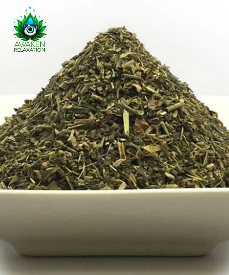 May include: A close-up of a white bowl filled with a large pile of dried green herbs. The herbs are a mix of different sizes and shapes, and they appear to be finely chopped.