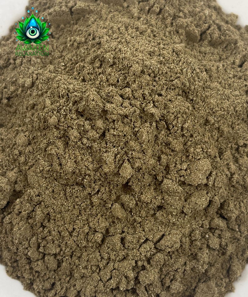 Puede incluir: Un polvo fino de tono marr&oacute;n terroso con una textura granular. En la esquina superior izquierda, un peque&ntilde;o logotipo presenta una flor de loto verde estilizada con un dise&ntilde;o de ojo central y el texto AVALON RELAXATION en letras may&uacute;sculas verdes.