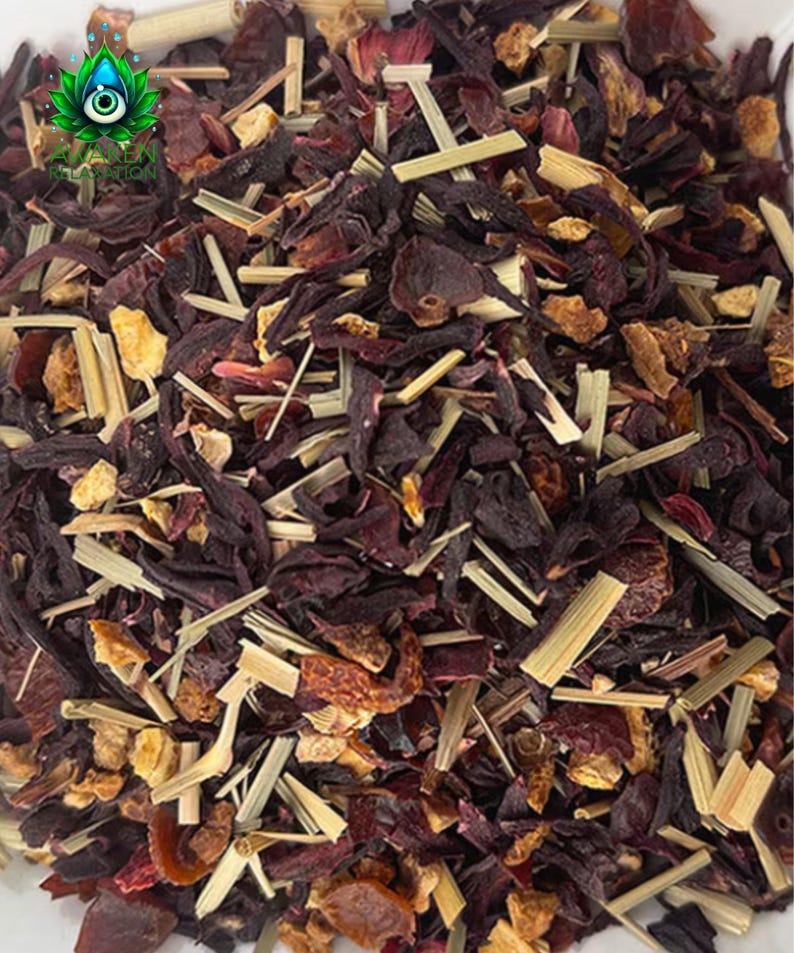 May include: Close-up of a blend of dried hibiscus flowers, orange peel, and lemongrass. The mixture is a vibrant red, orange, and brown.