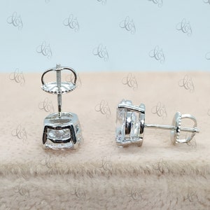 May include: A pair of silver stud earrings with clear cubic zirconia stones. The earrings have a simple, elegant design and are perfect for everyday wear.